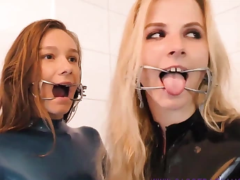 Two horny babes wearing latex and high heels making out take a nasty way